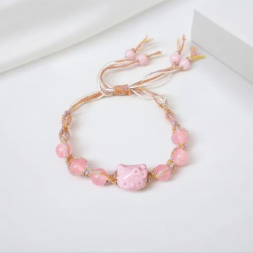 Gelang tali adjustable warna pastl dengan charm kepala kucing pink dan manik-manik pink mengkilap.